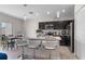 Modern kitchen with dark cabinetry, stainless steel appliances, a breakfast bar, and an adjacent dining area at 601 Watusi Way, St Cloud, FL 34772