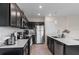 A modern kitchen features dark cabinets, stainless appliances, and a large quartz countertop at 601 Watusi Way, St Cloud, FL 34772