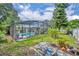 Backyard view with a screened pool enclosure featuring a hot tub, statues, a waterfall, and lush landscaping around the pool at 604 Ponca Trl, Maitland, FL 32751