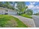 Exterior view of the home with a brick driveway leading to a garage, surrounded by a green lawn and trees at 604 Ponca Trl, Maitland, FL 32751