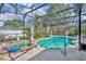 The screened in pool area features a hot tub, statues, and a waterfall cascading into the pool, perfect for relaxation at 604 Ponca Trl, Maitland, FL 32751