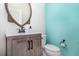 Bathroom featuring modern sink, mirror, and toilet, with a vibrant turquoise accent wall at 7184 Enchanted Lake Dr, Winter Garden, FL 34787
