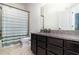 Bathroom featuring a shower/tub combo and dark cabinets with granite countertop at 7184 Enchanted Lake Dr, Winter Garden, FL 34787