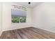 Bedroom with wood floors and a window overlooking green trees at 7184 Enchanted Lake Dr, Winter Garden, FL 34787