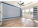 Spacious bedroom with wood floors and multiple windows with blue-striped curtains at 7184 Enchanted Lake Dr, Winter Garden, FL 34787