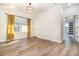 Bedroom with light wood floors, a modern light fixture, and bright natural light from a large window at 7184 Enchanted Lake Dr, Winter Garden, FL 34787