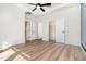 Large bedroom with wood floors, ceiling fan, and an adjacent bathroom and closet at 7184 Enchanted Lake Dr, Winter Garden, FL 34787
