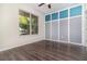 Bedroom with dark wood flooring, natural light, neutral walls, and a creative gray and blue accent wall at 7184 Enchanted Lake Dr, Winter Garden, FL 34787