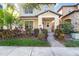 Charming two-story home with well-maintained landscaping, including a palm tree and colorful bushes at 7184 Enchanted Lake Dr, Winter Garden, FL 34787