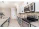Kitchen showcasing modern appliances, a stylish tile backsplash, granite counters, and sleek gray cabinets at 7184 Enchanted Lake Dr, Winter Garden, FL 34787