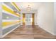 Bright room featuring light wood floors, a modern light fixture, and a playful accent wall with colorful stripes at 7184 Enchanted Lake Dr, Winter Garden, FL 34787