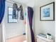 A view of a bathtub and toilet with a framed picture hanging above the toilet and next to purple curtains at 750 Sw 91St Pl, Ocala, FL 34476