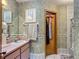 An ornate bathroom featuring wallpaper, a single vanity, and a combined shower-tub at 750 Sw 91St Pl, Ocala, FL 34476
