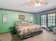 A bright bedroom with green walls and access to the outdoor patio with glass paneled doors at 750 Sw 91St Pl, Ocala, FL 34476