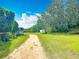 Gravel driveway leading towards the back of the property, showcasing open space, and natural landscape at 750 Sw 91St Pl, Ocala, FL 34476
