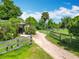 Dirt road leading to a charming farm property with lush greenery, mature trees, and fence at 750 Sw 91St Pl, Ocala, FL 34476