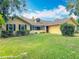 Charming yellow home with black shutters and lush landscaping at 750 Sw 91St Pl, Ocala, FL 34476