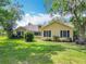 Charming yellow home with black shutters and lush landscaping at 750 Sw 91St Pl, Ocala, FL 34476