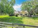 Charming yellow home with black shutters and lush landscaping at 750 Sw 91St Pl, Ocala, FL 34476