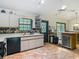Well-lit kitchen featuring tiled flooring, an island with drink storage, and exterior screened-in patio views at 750 Sw 91St Pl, Ocala, FL 34476