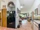 A view of the kitchen and living room with tile floors and stainless steel refrigerator at 750 Sw 91St Pl, Ocala, FL 34476
