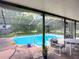 Screened-in outdoor pool area featuring pool, patio chairs, lush foliage, and screened pool enclosure at 750 Sw 91St Pl, Ocala, FL 34476