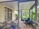 Screened-in porch featuring an outside seating area with a view of lush greenery and wooden door at 750 Sw 91St Pl, Ocala, FL 34476