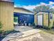 View of various outbuildings and storage sheds with a concrete pathway at 750 Sw 91St Pl, Ocala, FL 34476