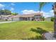 Beautiful home with lush green lawn and manicured flowerbeds, surrounded by mature trees at 801 Hunt Dr, Lake Wales, FL 33853