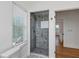 Elegant bathroom featuring glass shower doors and tasteful tilework, enhanced by natural light at 802 S 10Th St, Haines City, FL 33844