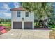 Two-story stucco home features a two-car garage, red tile roof, and an elevated balcony at 802 S 10Th St, Haines City, FL 33844