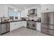 Stylish kitchen with white cabinets, stainless steel appliances, and modern backsplash with tile flooring at 802 S 10Th St, Haines City, FL 33844