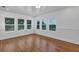 Sunlit room with hardwood floors, white trim, and multiple windows offering scenic views at 802 S 10Th St, Haines City, FL 33844