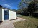 The backyard reveals a well-maintained lawn, bordered by a privacy fence, leading to a sparkling pool, accessible via a quaint blue door at 804 Starke Lake Cir, Ocoee, FL 34761