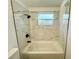 Renovated bathroom featuring a tub, marble-style tiling, and sleek black fixtures at 804 Starke Lake Cir, Ocoee, FL 34761