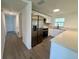Modern kitchen featuring stainless steel appliances, white cabinets, and an adjacent hallway at 804 Starke Lake Cir, Ocoee, FL 34761