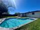 Sunlit pool area features a uniquely shaped pool, seamlessly blending with a well-maintained yard for outdoor enjoyment at 804 Starke Lake Cir, Ocoee, FL 34761
