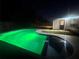 Night view of the pool, featuring vibrant, green lighting, setting a lively and inviting ambiance for evening swims at 804 Starke Lake Cir, Ocoee, FL 34761