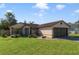 Charming single-story home with a well-manicured front lawn and beautiful landscaping at 925 S Dean Cir, Deltona, FL 32738