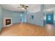 Spacious room with a fireplace, wood floors, a ceiling fan, and an exterior door at 925 S Dean Cir, Deltona, FL 32738