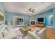 Bright living room with a decorative fireplace, a ceiling fan, wood floors, and sliding glass doors at 925 S Dean Cir, Deltona, FL 32738