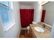 Bathroom featuring a shower with a red curtain, vanity and a window at 5723 Harcourt Ave, Orlando, FL 32810