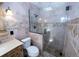 A marble bathroom with a shower featuring a skylight and glass door at 5723 Harcourt Ave, Orlando, FL 32810