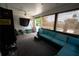 View of the sunroom from the opposite side features a large couch and direct access to the pool at 5723 Harcourt Ave, Orlando, FL 32810