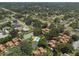 An aerial view featuring a community pool and tennis court, surrounded by lush trees and residential homes at 104 Oaks Ct, Sanford, FL 32771
