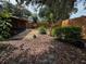 An outdoor view of the backyard with mulch, bushes and trees at 104 Oaks Ct, Sanford, FL 32771