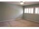 Bright bedroom features neutral walls, carpeted floor, ceiling fan and two windows fitted with bright white shutters at 104 Oaks Ct, Sanford, FL 32771