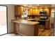 Modern kitchen with stainless steel appliances, breakfast bar, wood cabinets, and hardwood floors at 104 Oaks Ct, Sanford, FL 32771