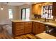 Modern kitchen features wood cabinets, stainless steel appliances, bar seating, and hardwood floors at 104 Oaks Ct, Sanford, FL 32771