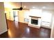 Bright living room features a white brick fireplace, hardwood floors, windows with shutters, and fan at 104 Oaks Ct, Sanford, FL 32771